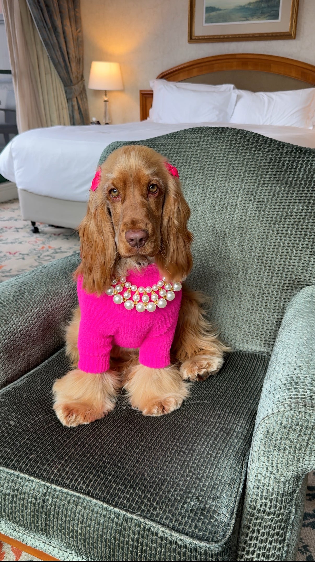 Princess Penny wearing a bright pink coat and pearl necklace